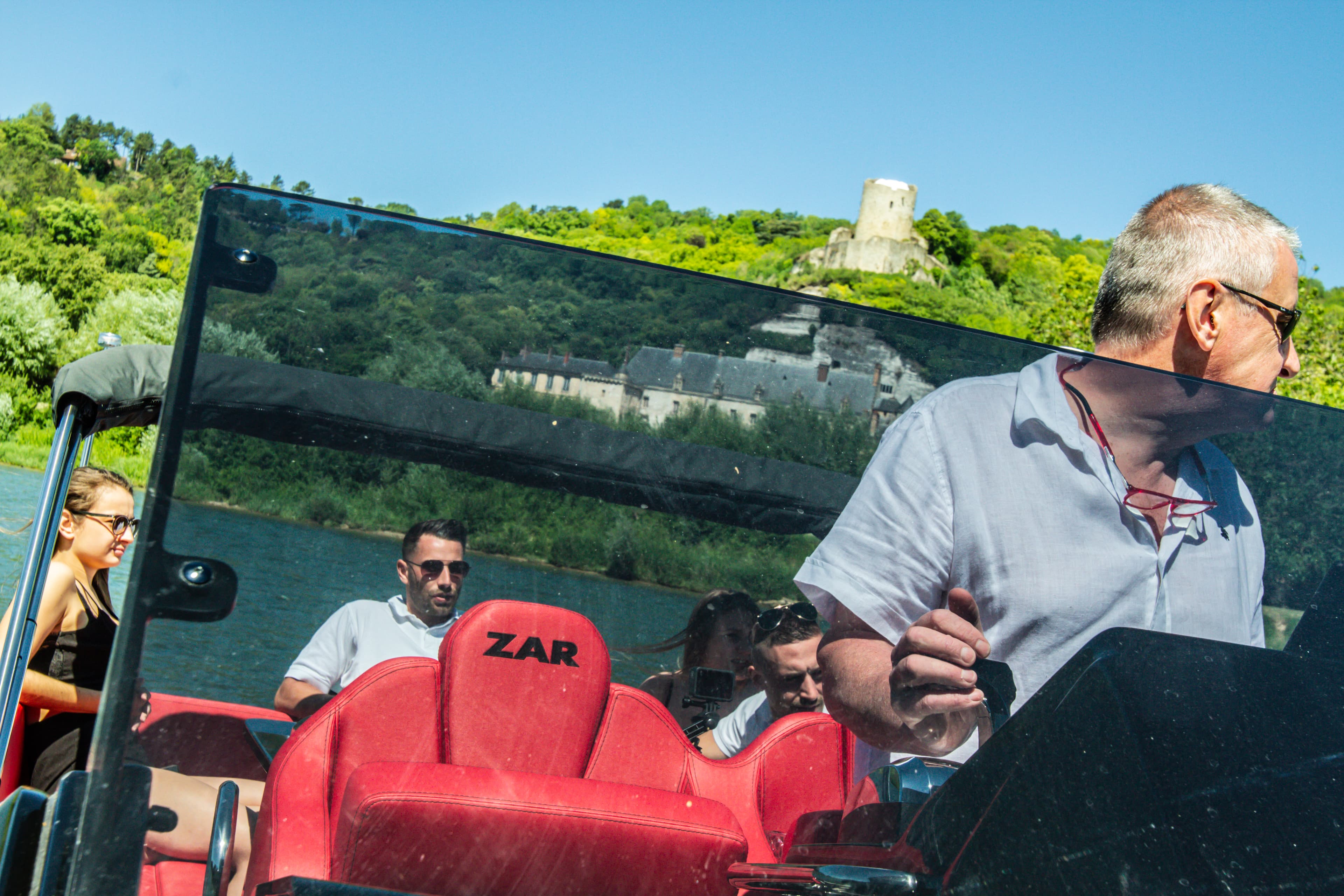 photo Christophe conduisant le bateau avec le chateau de la roche guyon en fond